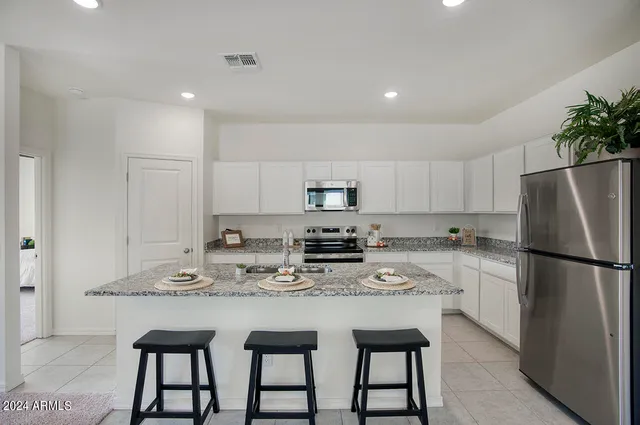 a kitchen with stainless steel appliances granite countertop a white cabinets and a refrigerator