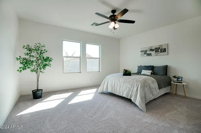 a spacious bedroom with a bed and a chandelier