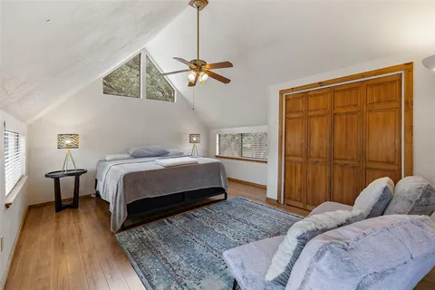 a bedroom with a bed a dresser and flowerpot