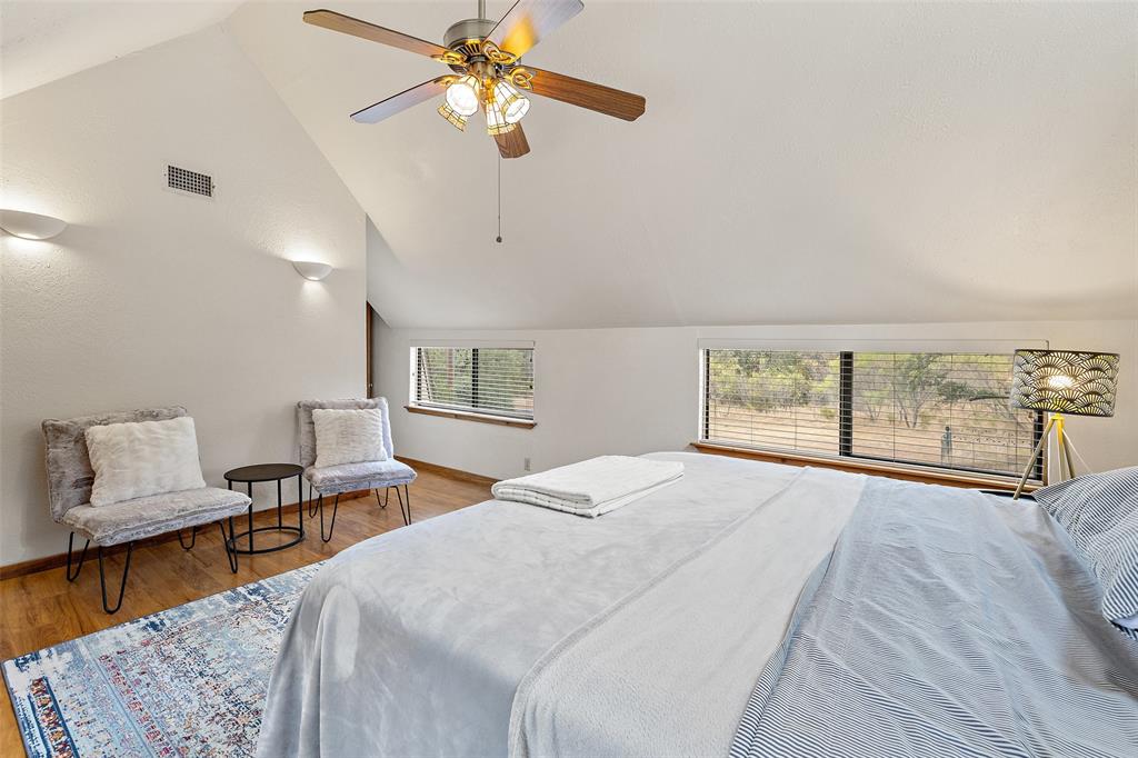 318 Coventry Road Spicewood, TX 78669 - Photo 13 of 38 Bedroom featuring lofted ceiling, ceiling fan, and wood finished floors
