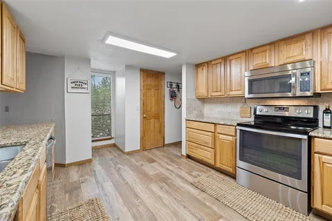 a kitchen with stainless steel appliances granite countertop a stove a microwave and a refrigerator
