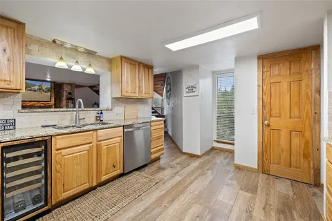 a kitchen with stainless steel appliances granite countertop a refrigerator a sink and dishwasher with wooden floor