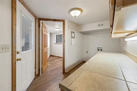 a view of a hallway with wooden floor and staircase