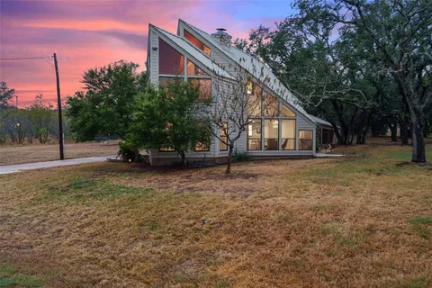 a view of a house with a tree in the yard