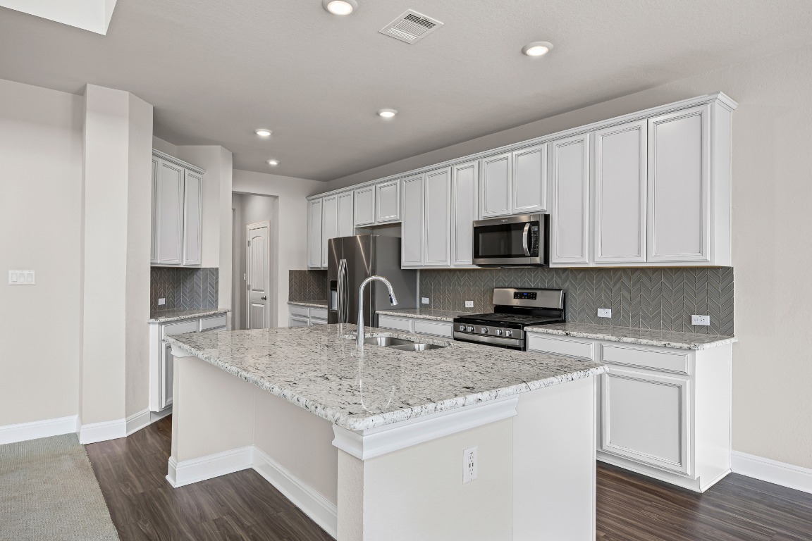187 Glass Mountain Way Dripping Springs, TX 78620 - Photo 9 of 35 a kitchen with appliances a sink and cabinets