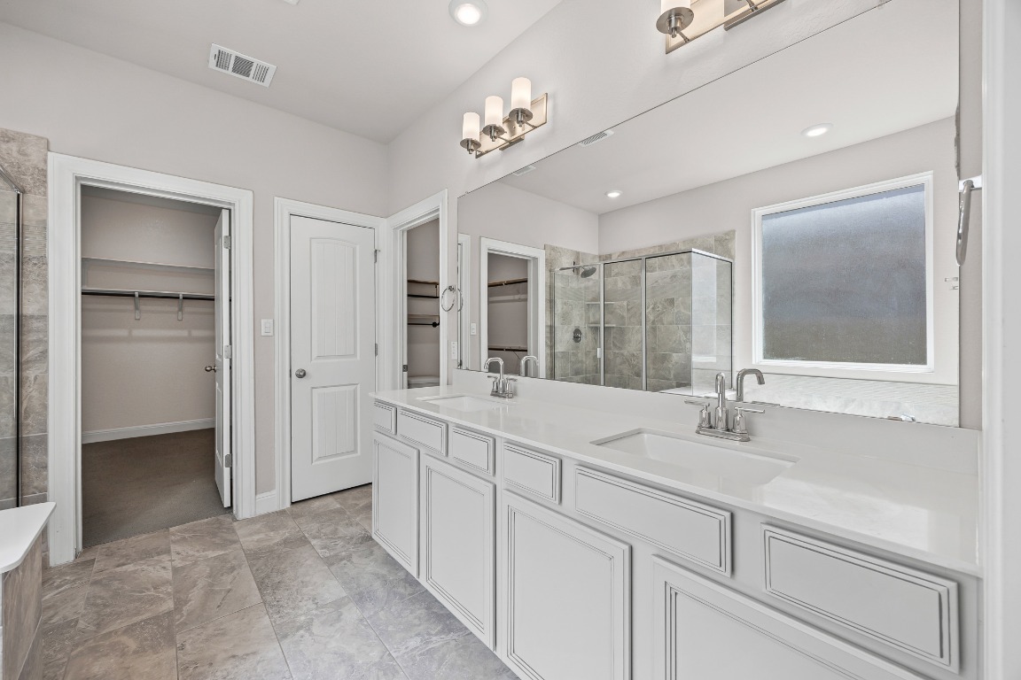 187 Glass Mountain Way Dripping Springs, TX 78620 - Photo 17 of 35 a bathroom with a double vanity sink and a mirror