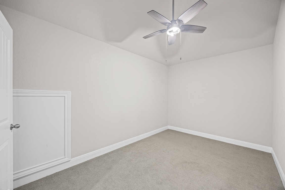 187 Glass Mountain Way Dripping Springs, TX 78620 - Photo 26 of 35 an empty room with a chandelier fan and windows