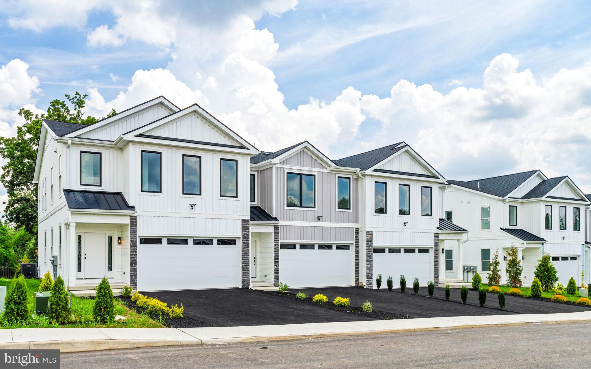 a white house with tall trees in front of it