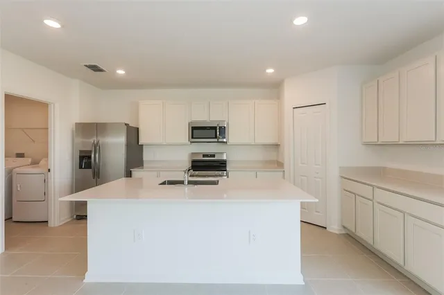 a kitchen with stainless steel appliances a refrigerator sink stove microwave and cabinets