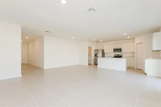 a view of kitchen with kitchen island a white cabinets and white appliances