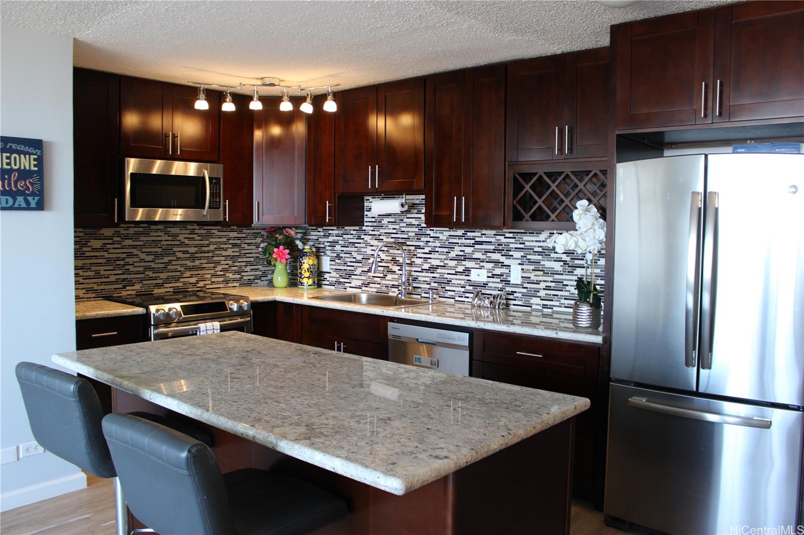 a kitchen with stainless steel appliances granite countertop a table chairs sink and refrigerator