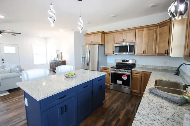 a kitchen with stainless steel appliances granite countertop a sink stove and refrigerator