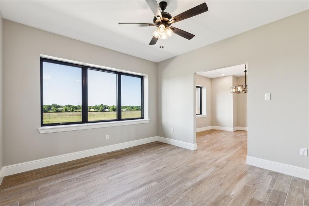 700 Brown Road Palo Pinto, TX 76484 - Photo 17 of 40 Den featuring natural light, wood look tile floors, baseboards, and ceiling fan.
