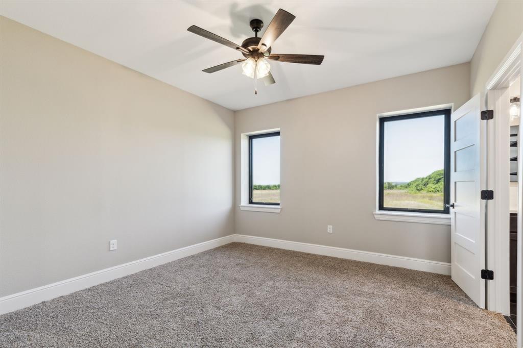 700 Brown Road Palo Pinto, TX 76484 - Photo 19 of 40 Carpeted primary bedroom featuring baseboards and a ceiling fan.