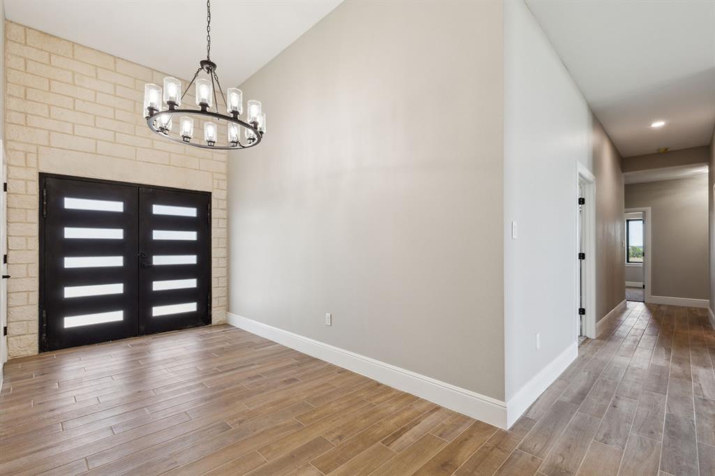 700 Brown Road Palo Pinto, TX 76484 - Photo 4 of 40 Entrance foyer featuring baseboards, wood look tile floors, and an inviting chandelier