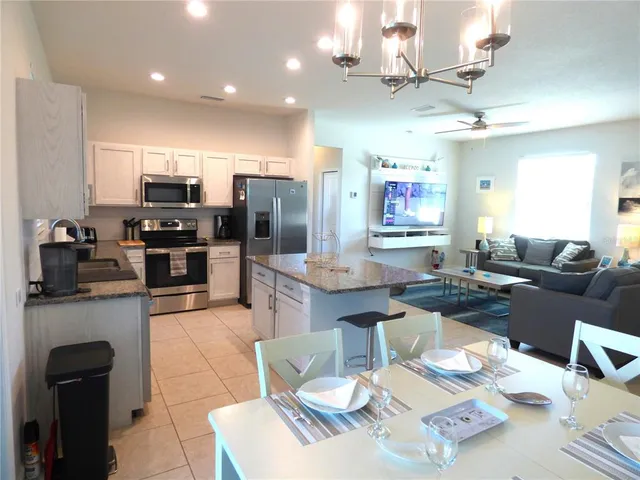 a kitchen with granite countertop a sink dishwasher stove and cabinets