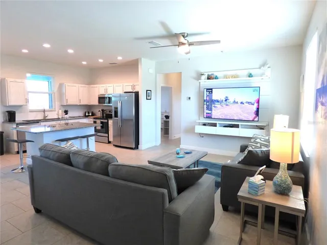 a living room with stainless steel appliances kitchen island granite countertop furniture and a view of kitchen