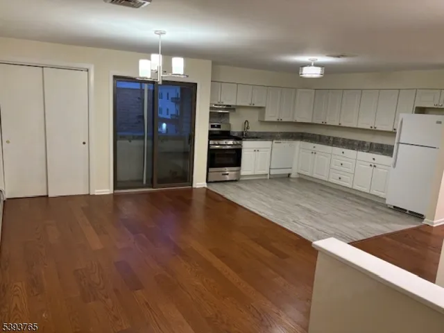 a kitchen with stainless steel appliances granite countertop a refrigerator and a stove top oven