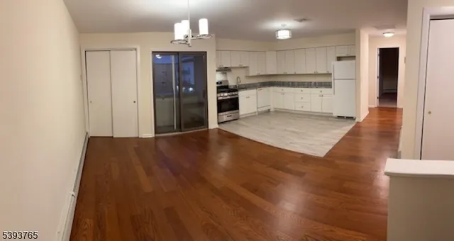 a view of kitchen with cabinets appliances and wooden floor