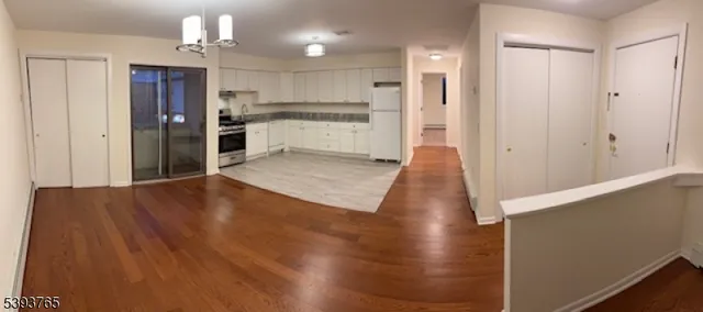 a view of a kitchen with wooden floor and a refrigerator