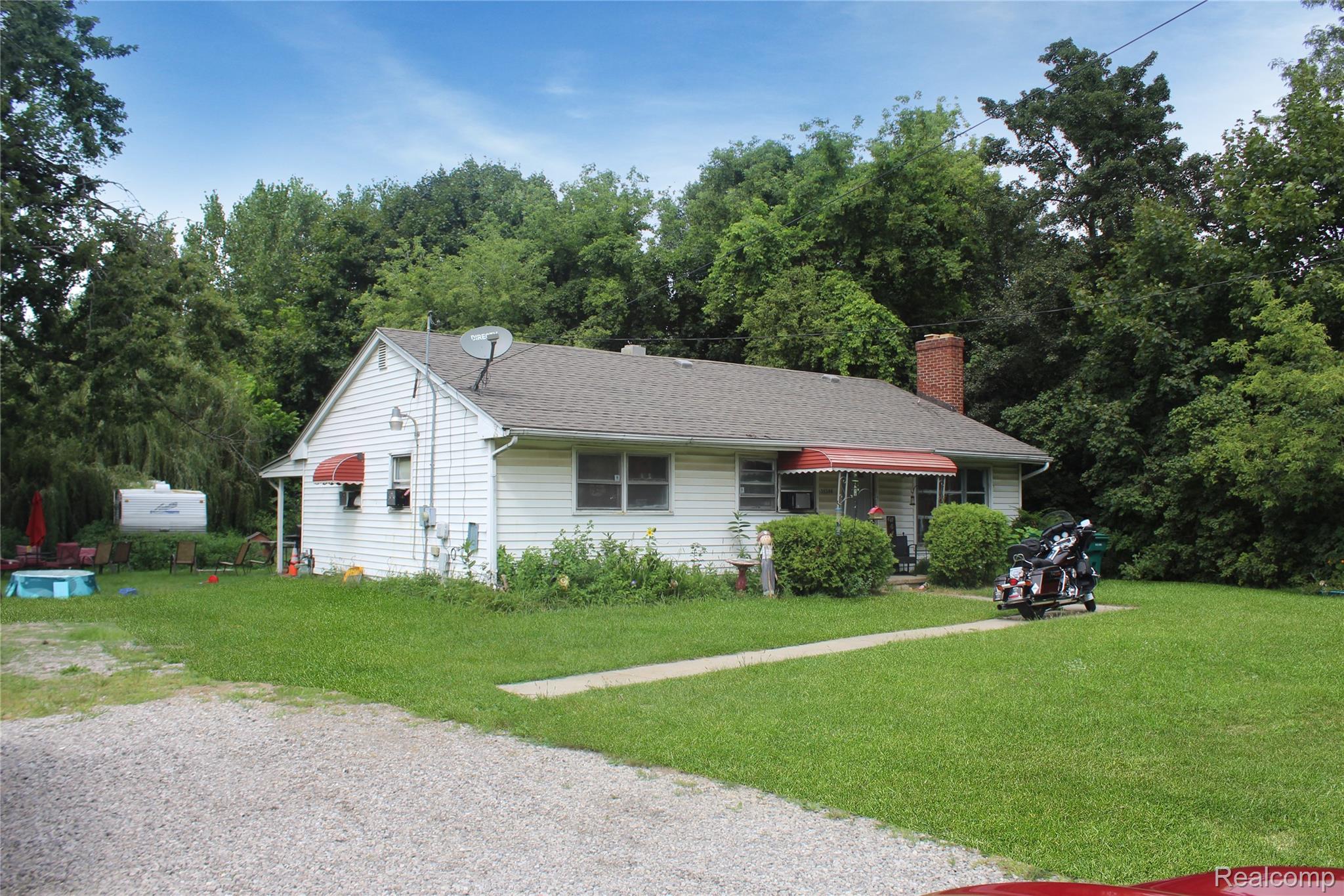 35344 Ecorse Road Romulus, MI 48174 - Photo 1 of 3 View of front facade featuring a front lawn, a chimney, and roof with shingles