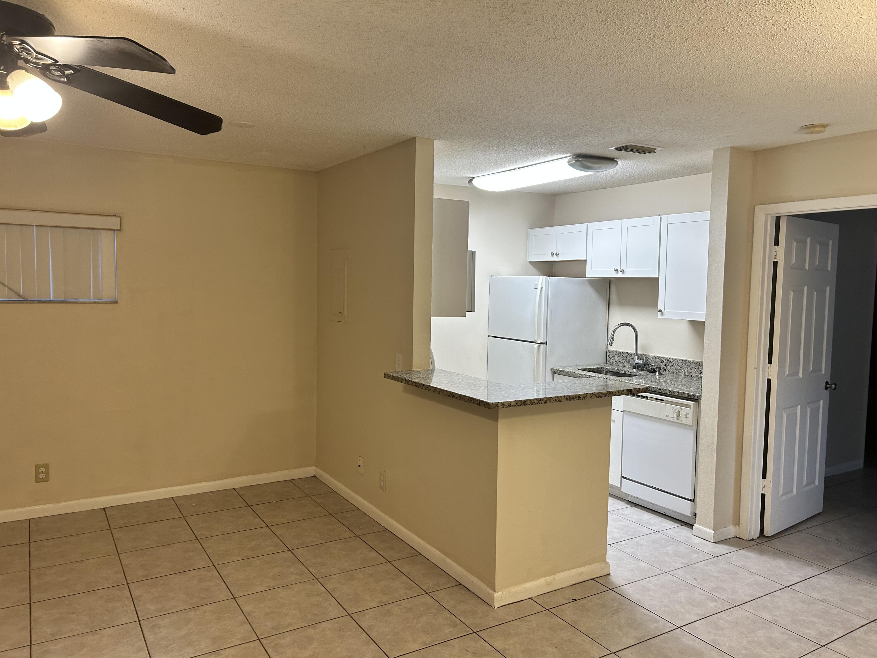 23 Crossings Circle, Unit E Boynton Beach, FL 33435 - Photo 4 of 15 a kitchen with a sink a refrigerator and cabinets