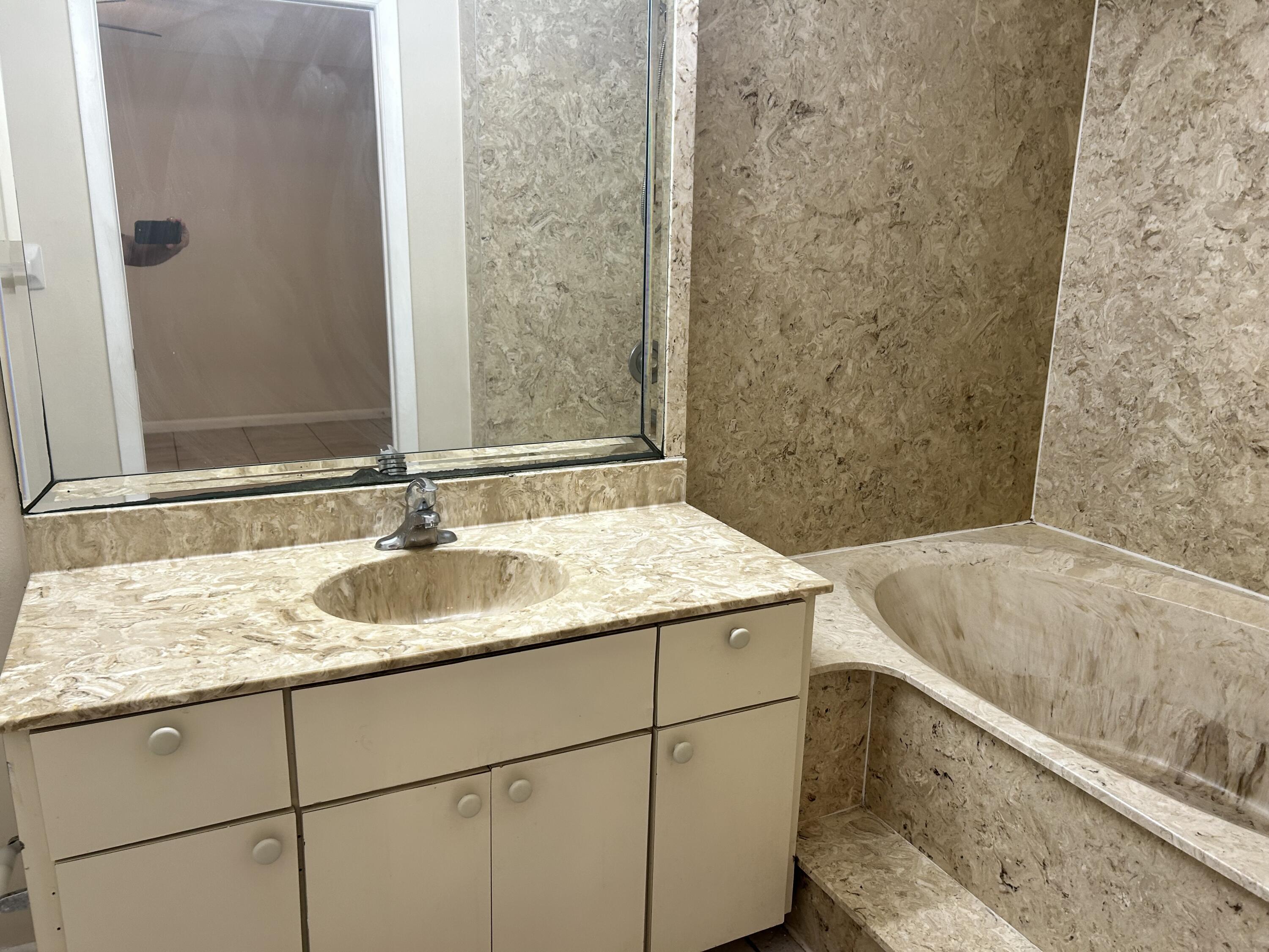 23 Crossings Circle, Unit E Boynton Beach, FL 33435 - Photo 9 of 15 a bathroom with a granite countertop sink and a bathtub