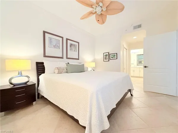 a spacious bedroom with a bed and a chandelier