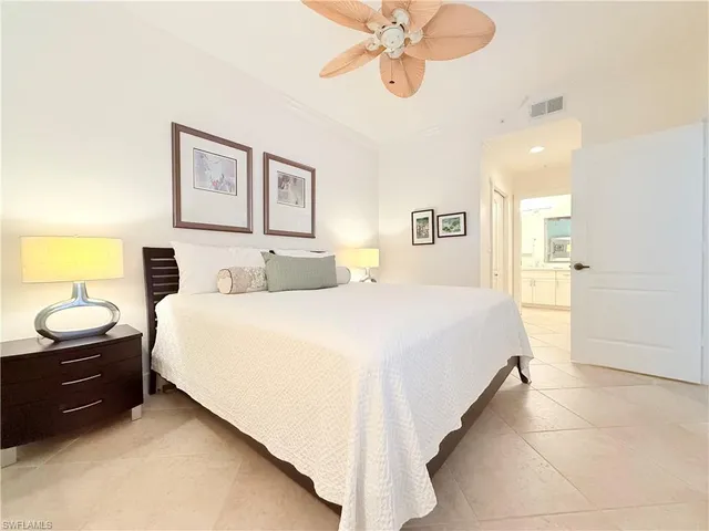 a spacious bedroom with a bed and a chandelier