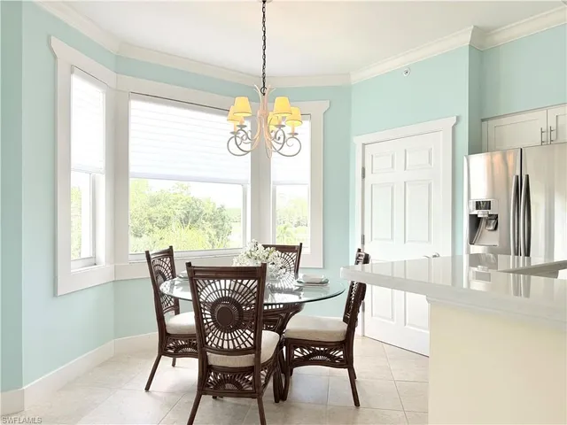 a dining room with furniture a chandelier and wooden floor