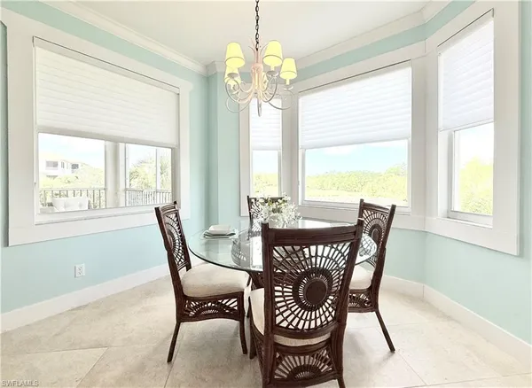 a view of a dining room with furniture a chandelier and wooden floor
