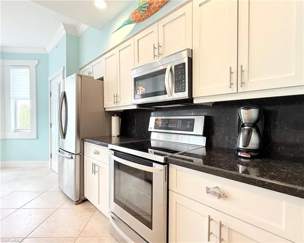 a kitchen with stainless steel appliances granite countertop a stove microwave and refrigerator