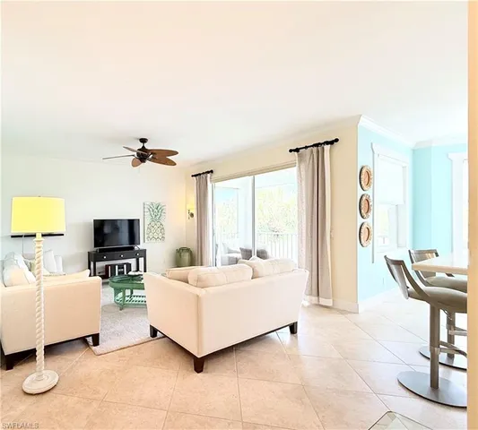 a spacious bedroom with a bed a couch and two windows