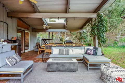 a living room with patio furniture and a garden