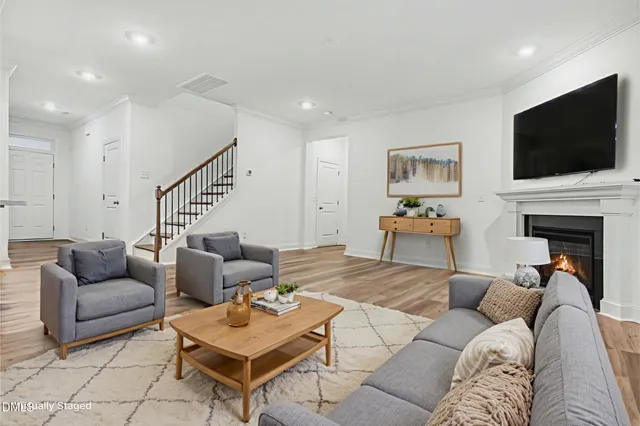 a living room with furniture a flat screen tv and a fireplace
