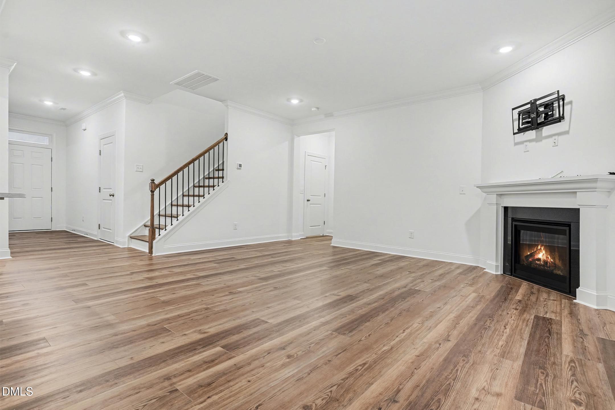 1328 Hazelnut Ridge Lane Knightdale, NC 27545 - Photo 13 of 50 a view of an empty room with wooden floor and a fireplace