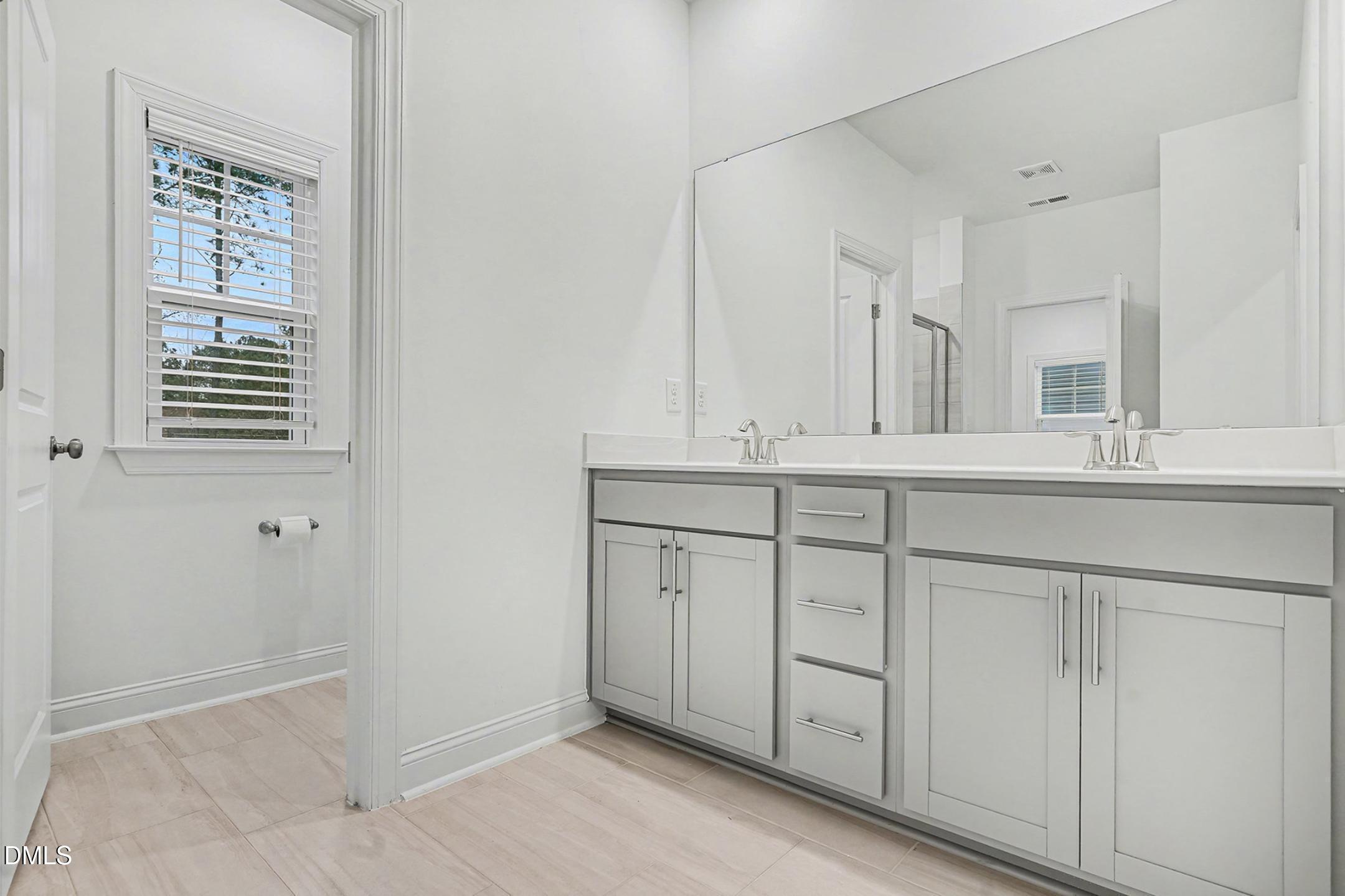 1328 Hazelnut Ridge Lane Knightdale, NC 27545 - Photo 27 of 50 a bathroom with a sink a vanity and a mirror