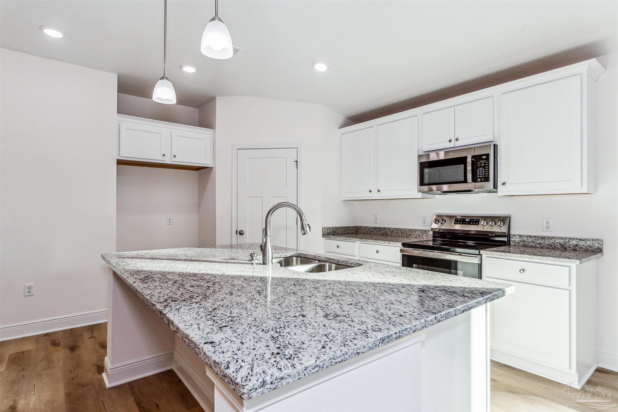 4613 Carl Booker Road Milton, FL 32583 - Photo 9 of 26 a kitchen with stainless steel appliances granite countertop a sink stove and cabinets