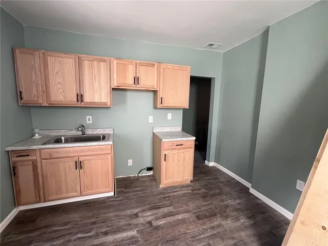 a kitchen with a sink cabinets and wooden floor