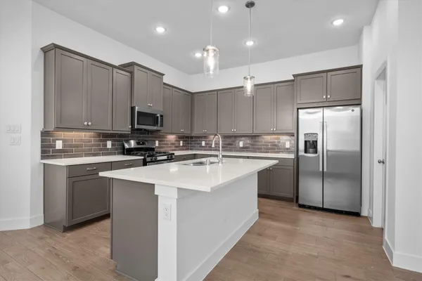 a kitchen with kitchen island a sink stainless steel appliances and cabinets