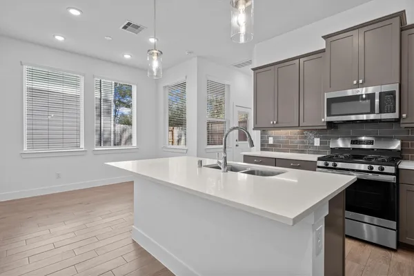 a kitchen with stainless steel appliances granite countertop a sink stove and microwave