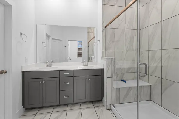 a bathroom with a double vanity sink and mirror