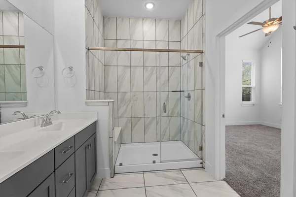 a bathroom with a shower sink and mirror