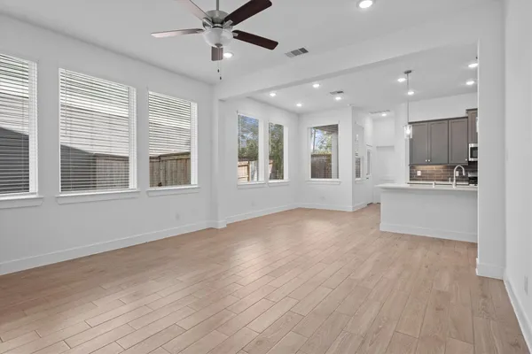 a view of an empty room with window and wooden floor