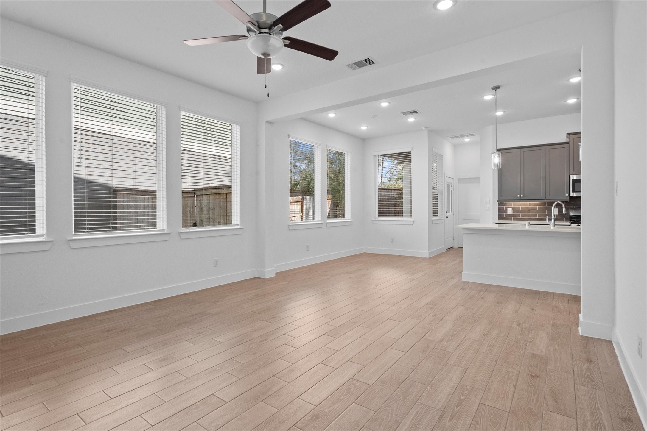 120 Red Cascade Trail Willis, TX 77318 - Photo 8 of 37 Bright living space with wood flooring, large windows with blinds, and a ceiling fan. Perfect for a cozy family setting.