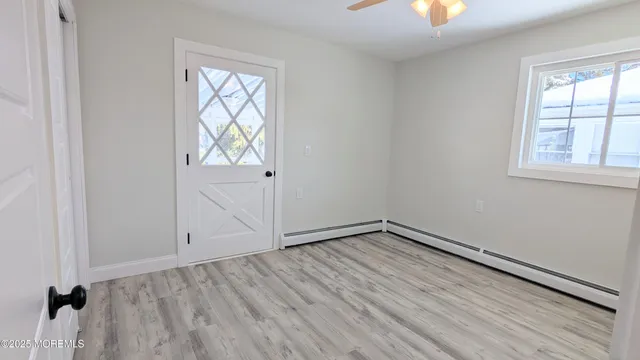an empty room with a window and wooden floor