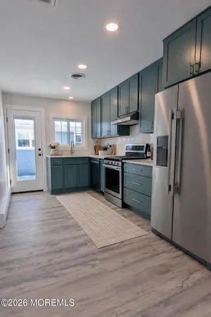 a open kitchen with stainless steel appliances granite countertop a stove and a refrigerator