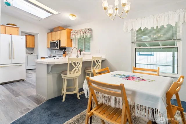 a view of a dining room with furniture a chandelier and wooden floor