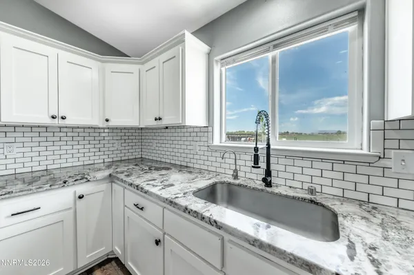 a bathroom with a sink a vanity a window and a mirror