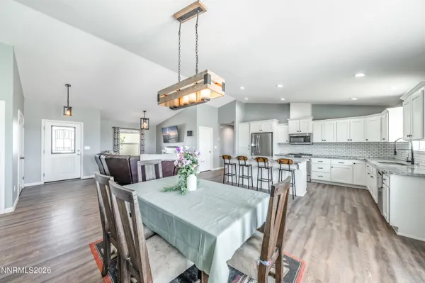 a view of a dining room and livingroom with furniture wooden floor a chandelier